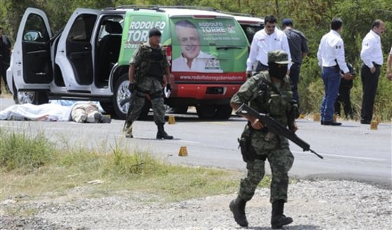 Army soldiers guard the crime scene after candidate for governor of the state of Tamaulipas, Rodolfo Torre, was ambushed by unidentified gunmen near Ciudad Victoria, Mexico, Monday. Gunmen assassinated the front-running candidate and several of his aides in what Mexico's President Felipe Calderon called an attempt by drug gangs to sway local and state elections this weekend.